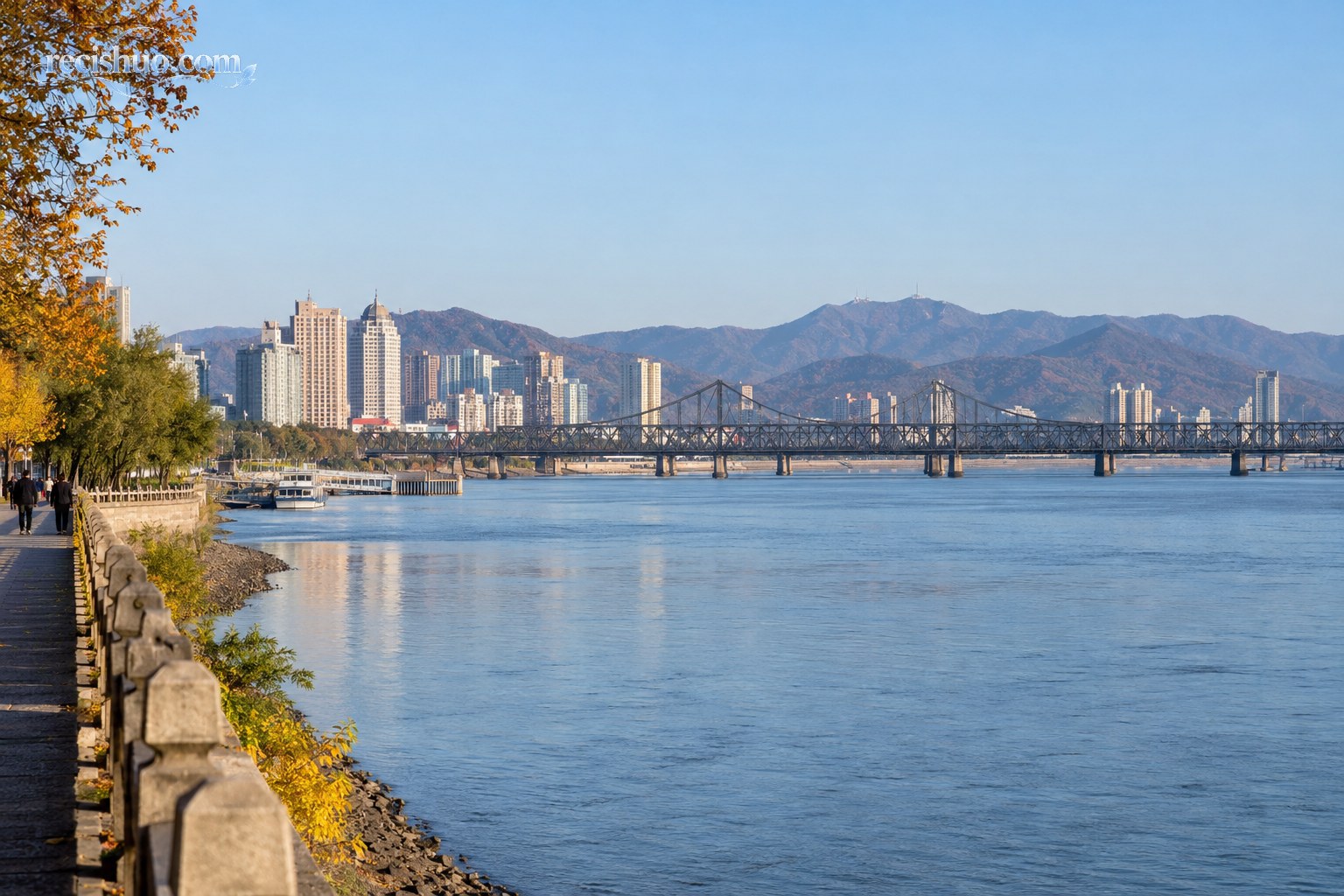 秋日丹东江面、城市建筑与跨江桥梁景观