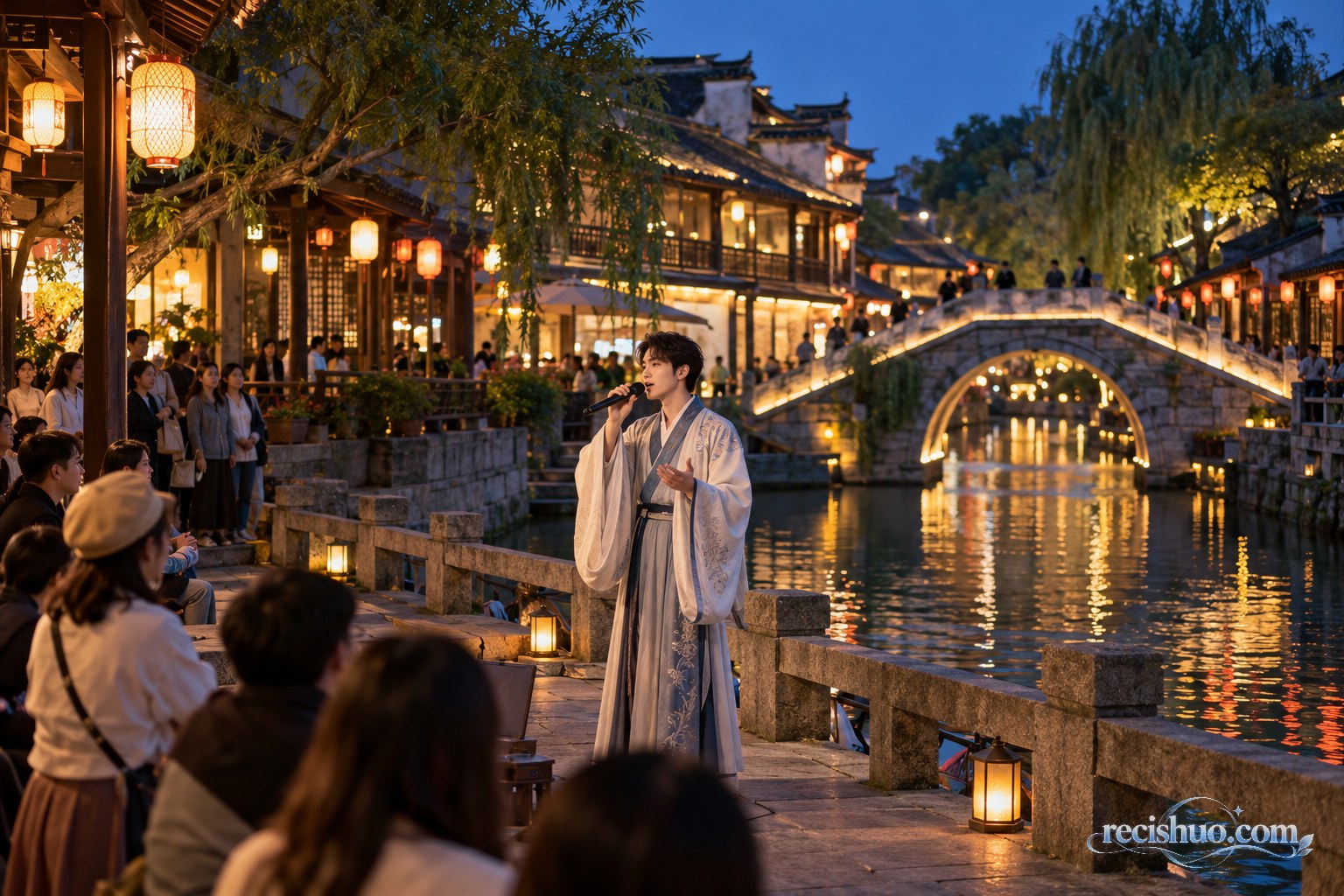 夜色老街河畔，一名古风装束的驻场演员在暖灯与石桥前演唱，游客有序观看