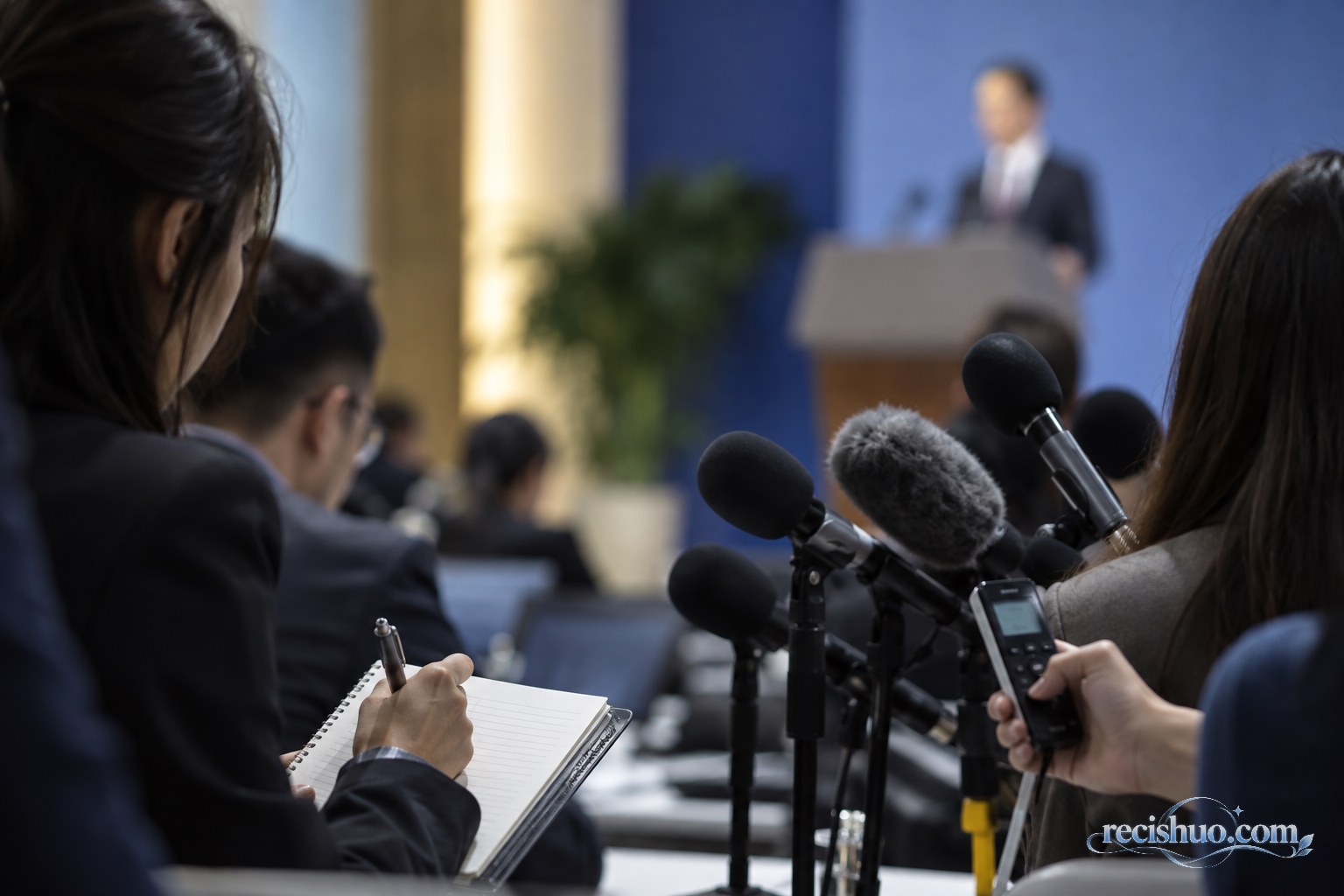 记者在正式发布会上使用笔记本和录音设备记录回应