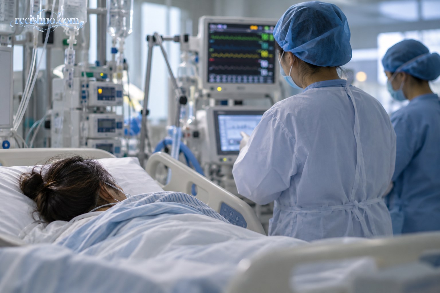 重症监护病房内医护人员查看一名女性患者的监护设备