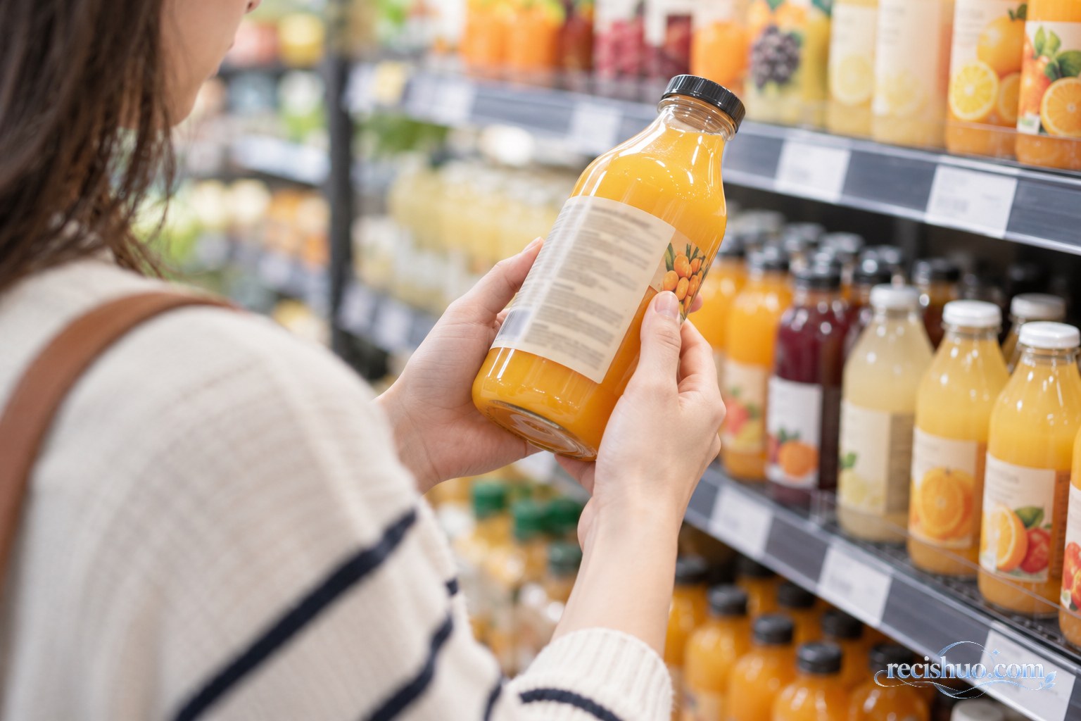 消费者在超市饮品货架前查看橙黄色果汁配料信息