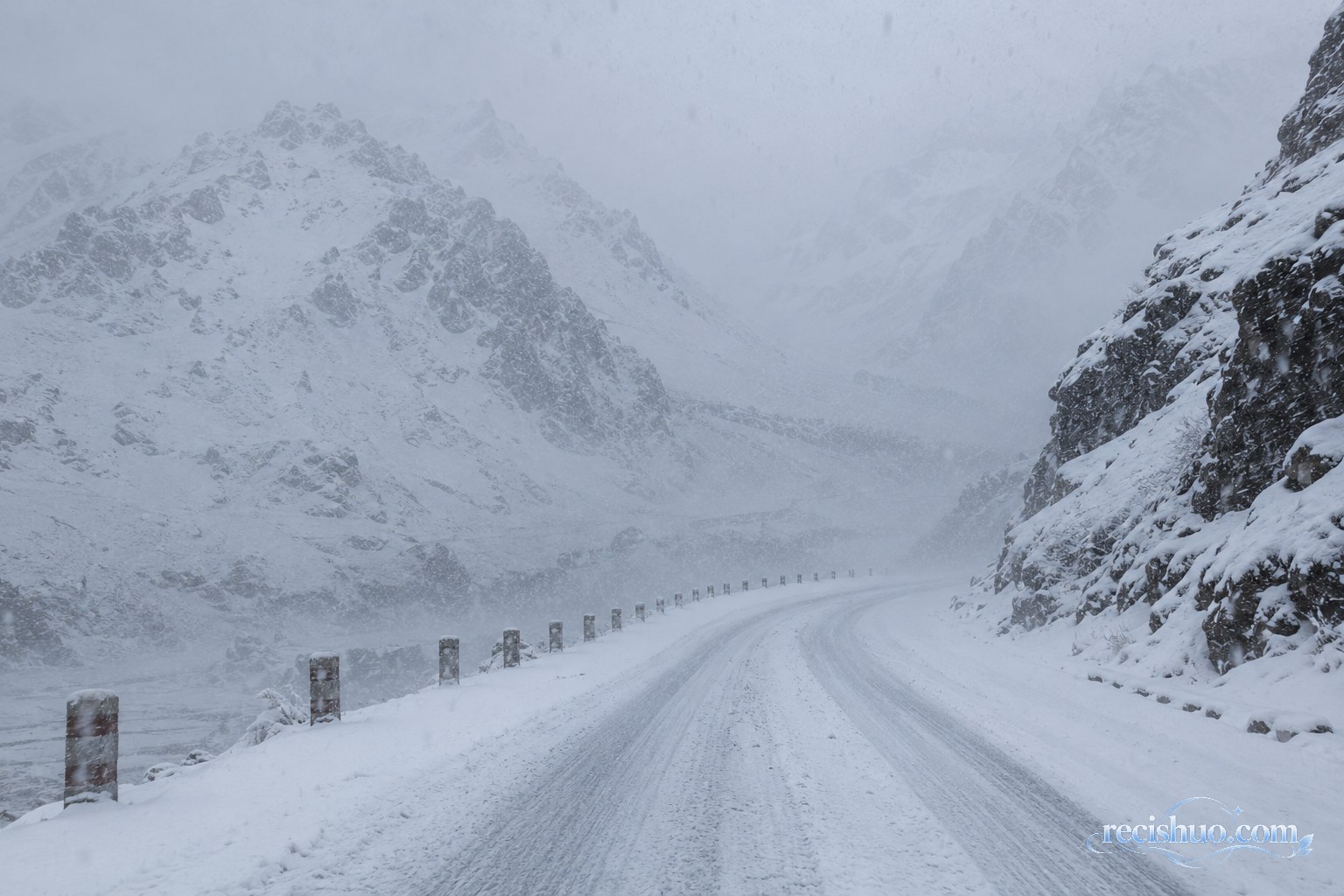 西藏南部高海拔山口公路遭遇强降雪，积雪覆盖路面并降低能见度